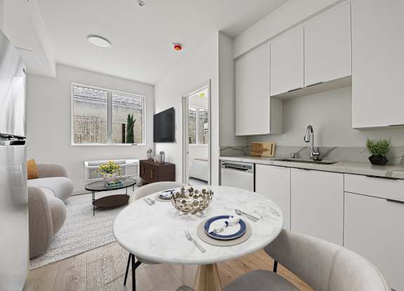 A modern kitchen with a dining table set for two.
