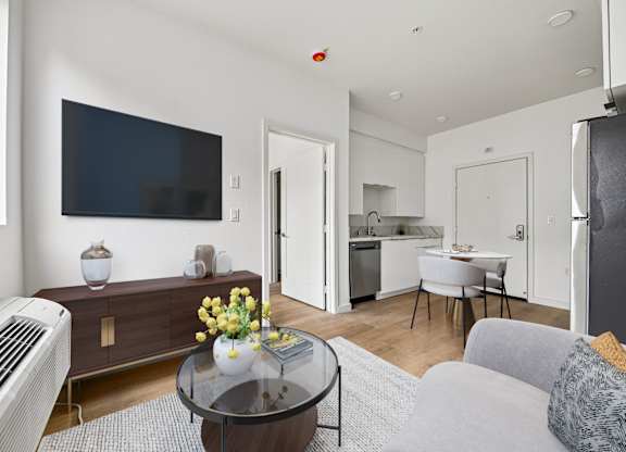 A living room with a television, a sofa, and a coffee table.