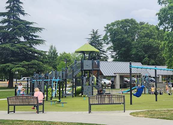 A playground with a green roof and a slide.