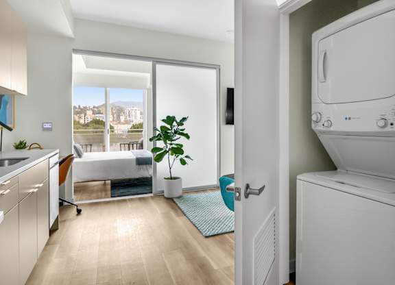 a bedroom with a large window and a washer and dryer