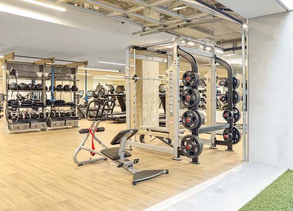 a spacious fitness room with a lot of exercise equipment