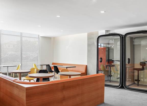 a seating area with tables and chairs in front of a glass door