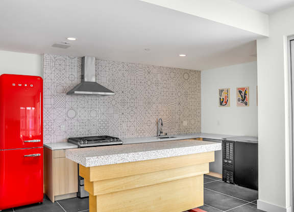 a kitchen with a large island and a red fridge