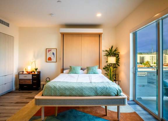 a bedroom with a bed and a large window
