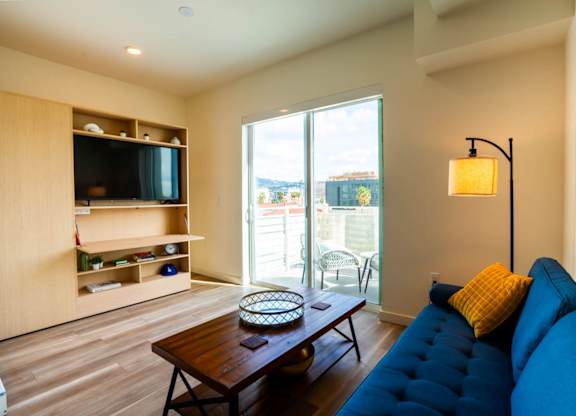 a living room with a blue couch and a television