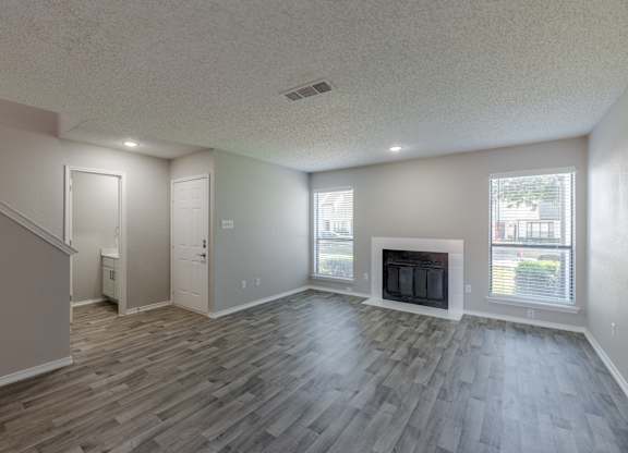 A living room with a fireplace and wood flooring.