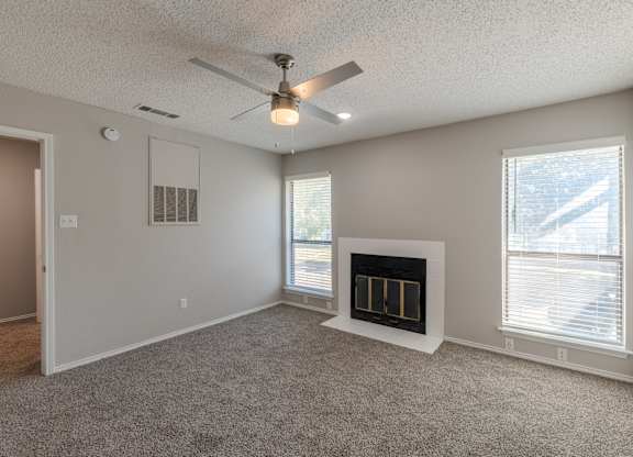 A room with a fireplace and a ceiling fan.