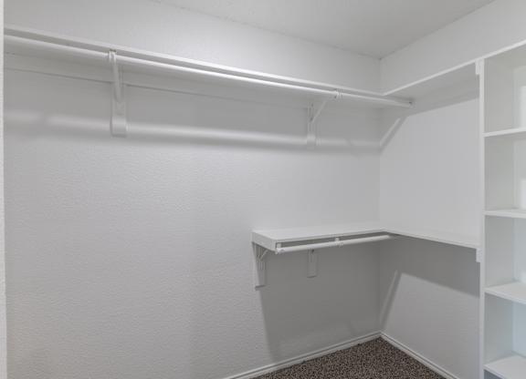 A white closet with shelves and a hanging rod.