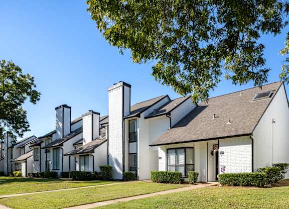 A white house with a black roof and chimney.