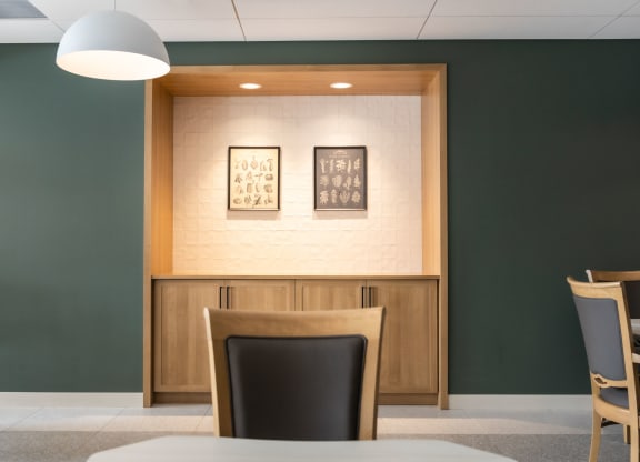 a room with a table and chairs and two pictures on the wall