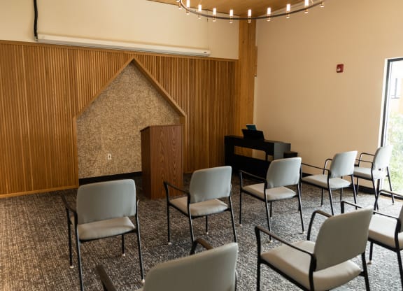 a room with a piano and chairs