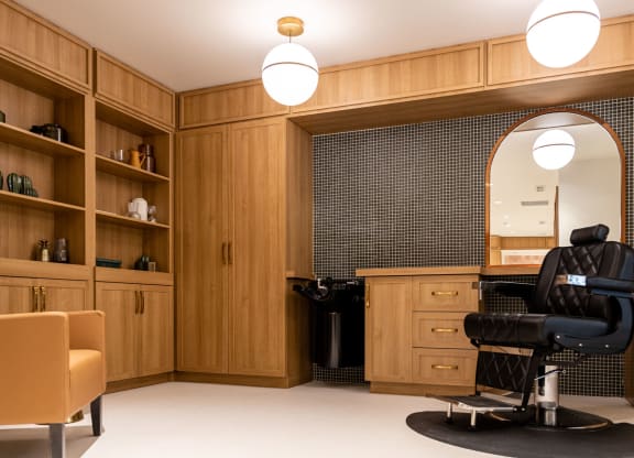 a salon room with wood cabinetry and a black salon chair