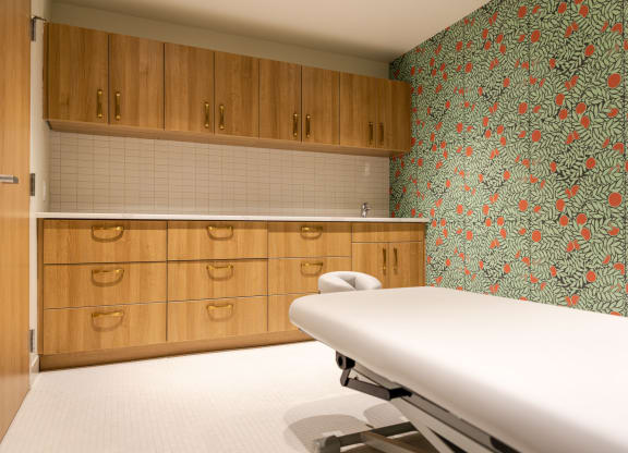 a room with a white table and a wall with a red and green floral wallpaper