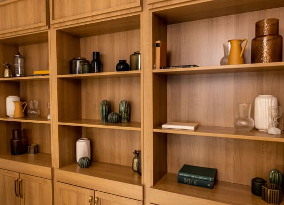 a wooden bookshelf with a variety of jars and vases on it