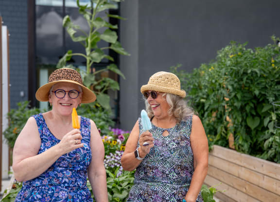 two women eating ice cream in a garden