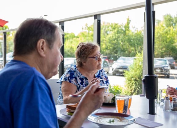a man and a woman sitting at a table eating food