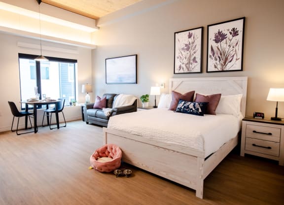 a bedroom with a bed and a chair in a room