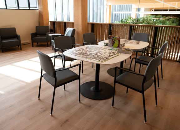 a table and chairs in a room with wooden floors and windows