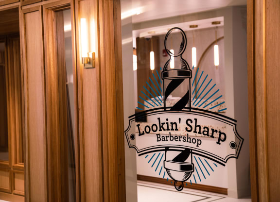 a sign on a door that says lookin sharp barbershop