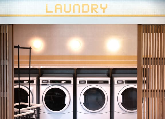 a row of washers and dryers in a laundromat