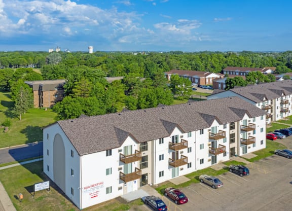 A large white building with a parking lot in front of it.