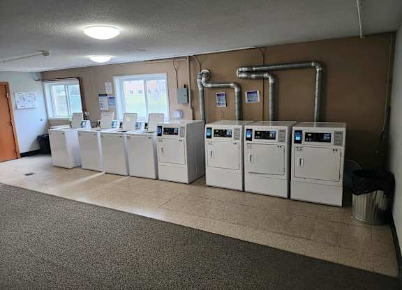 A row of white machines are lined up in a room.