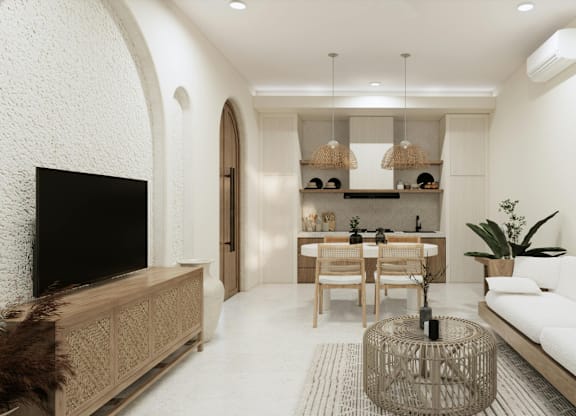 A living room with a white couch, a television, and a wooden cabinet.