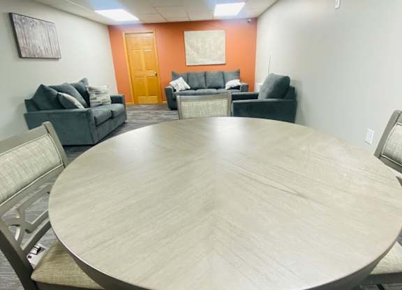 A conference room with a large table and chairs.