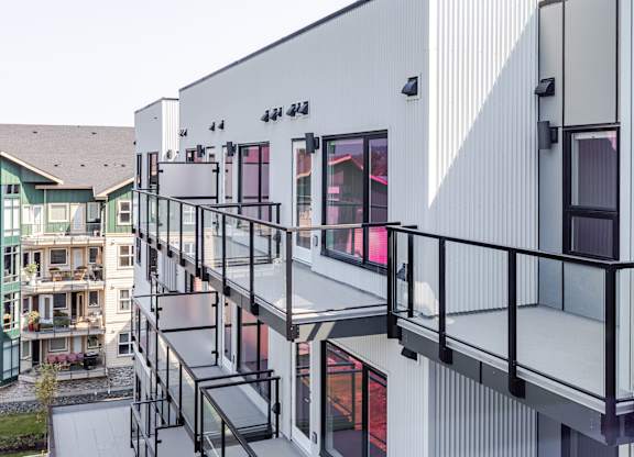A modern building with a balcony and a glass railing.