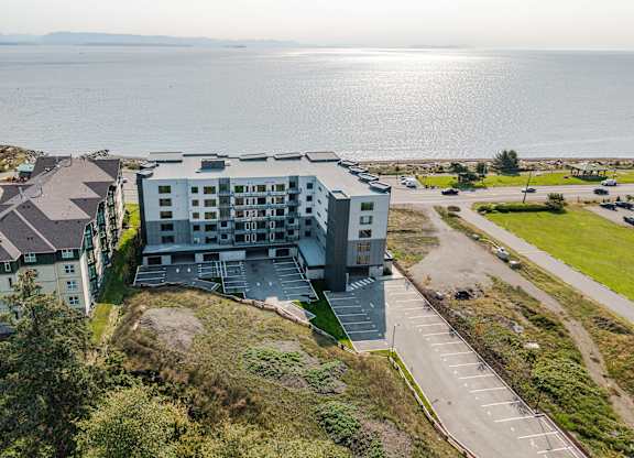 A large white building with a parking lot in front of it.