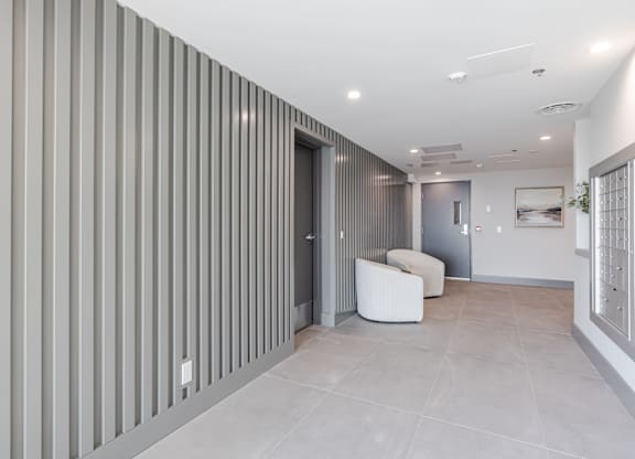 A modern room with a white chair and a grey wall.