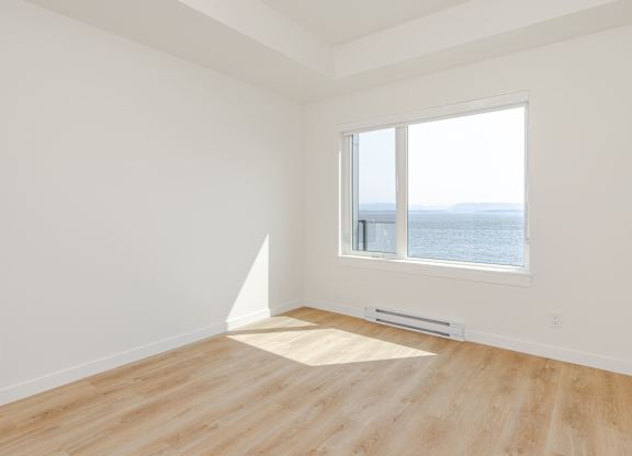 A room with a window overlooking the ocean.