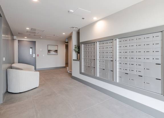A white reception area with a large white table and a white wall with a framed picture.