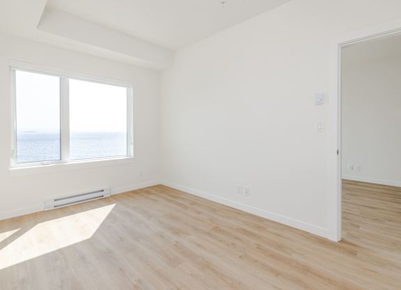 A room with a window overlooking the sea.