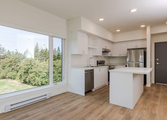 A modern kitchen with a large island and stainless steel appliances.