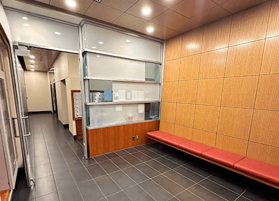A long hallway with a bench and a wall of cabinets.