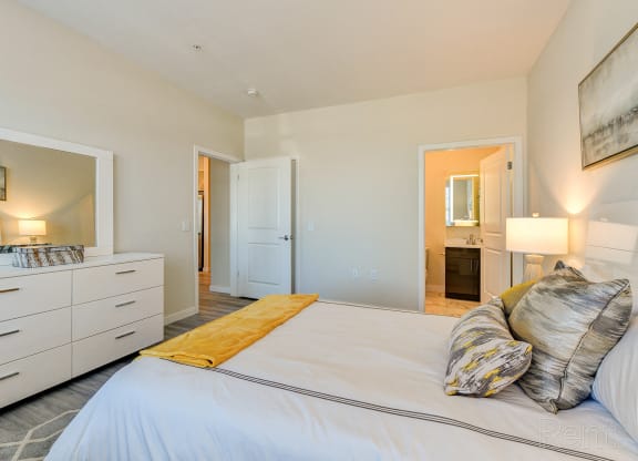 a bedroom with a large white bed and a bathroom at Solo at North Bergen, North Bergen, New Jersey