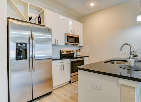 a kitchen with stainless steel appliances and a counter top at Solo at North Bergen, North Bergen