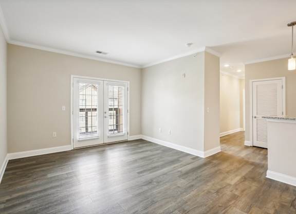 the living room and dining room in a new home with white walls and wood floors