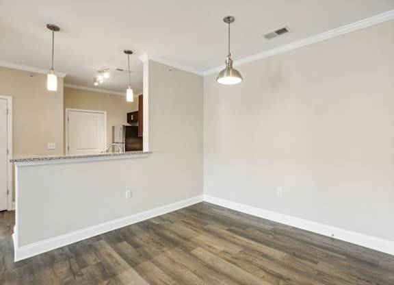an empty living room with wood flooring and white walls