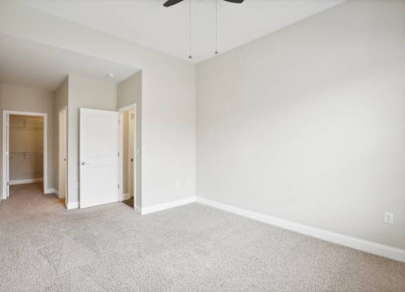an empty room with white walls and a ceiling fan