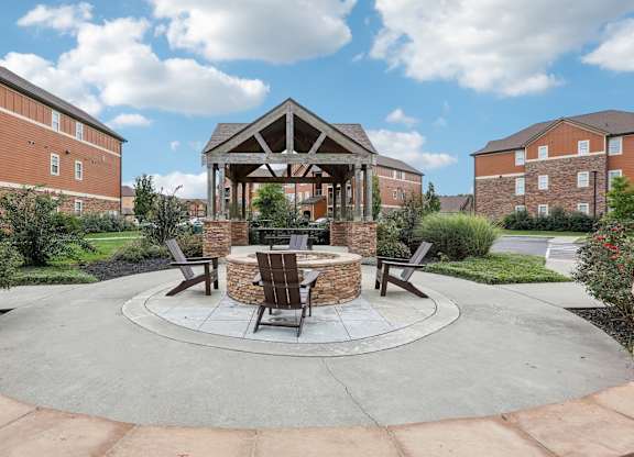 an outdoor patio with a fire pit and a gazebo