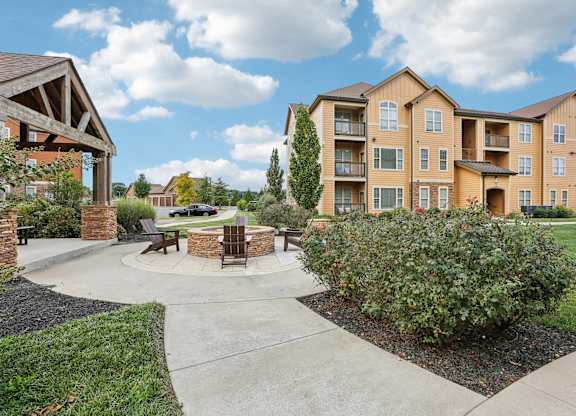 an outdoor patio with a fire pit in front of an apartment building