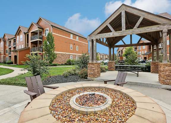 a fire pit with two chairs in front of a building