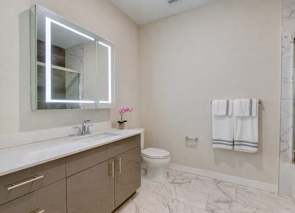 Modern bathroom with illuminated mirror and double vanity at The Rail North Bergen