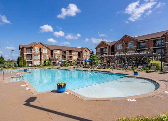 a swimming pool with an apartment building in the background