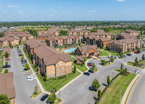 an aerial view of an apartment complex with cars parked in a parking lot