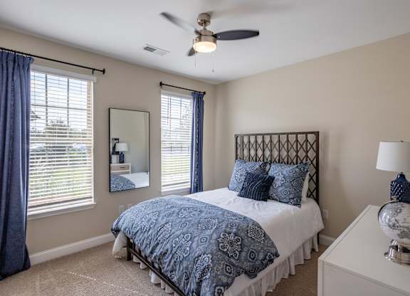 a bedroom with a bed and a ceiling fan