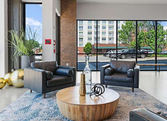 A modern living room with a blue rug and a wooden coffee table.