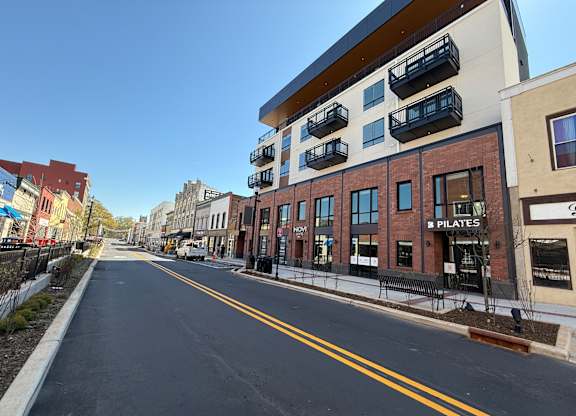A street view with a building that has a sign that says "PILATES".